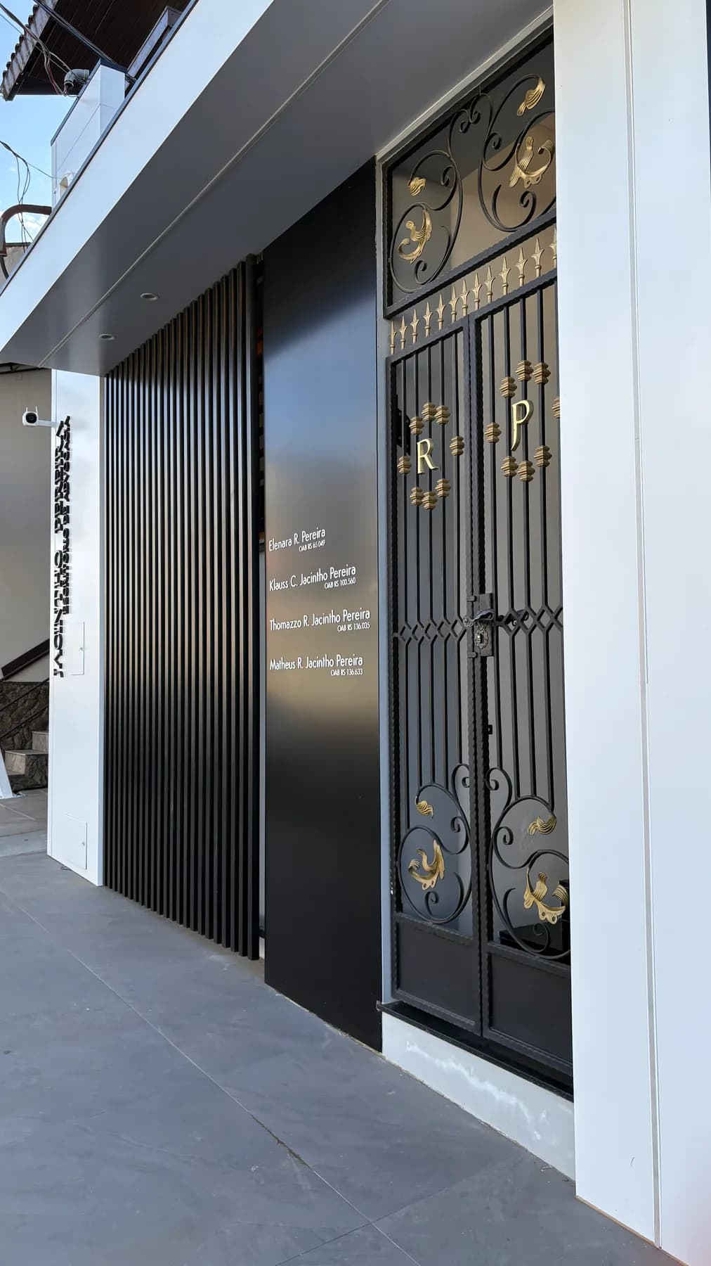 Entrada do escritório, com portão em ferro trabalhado