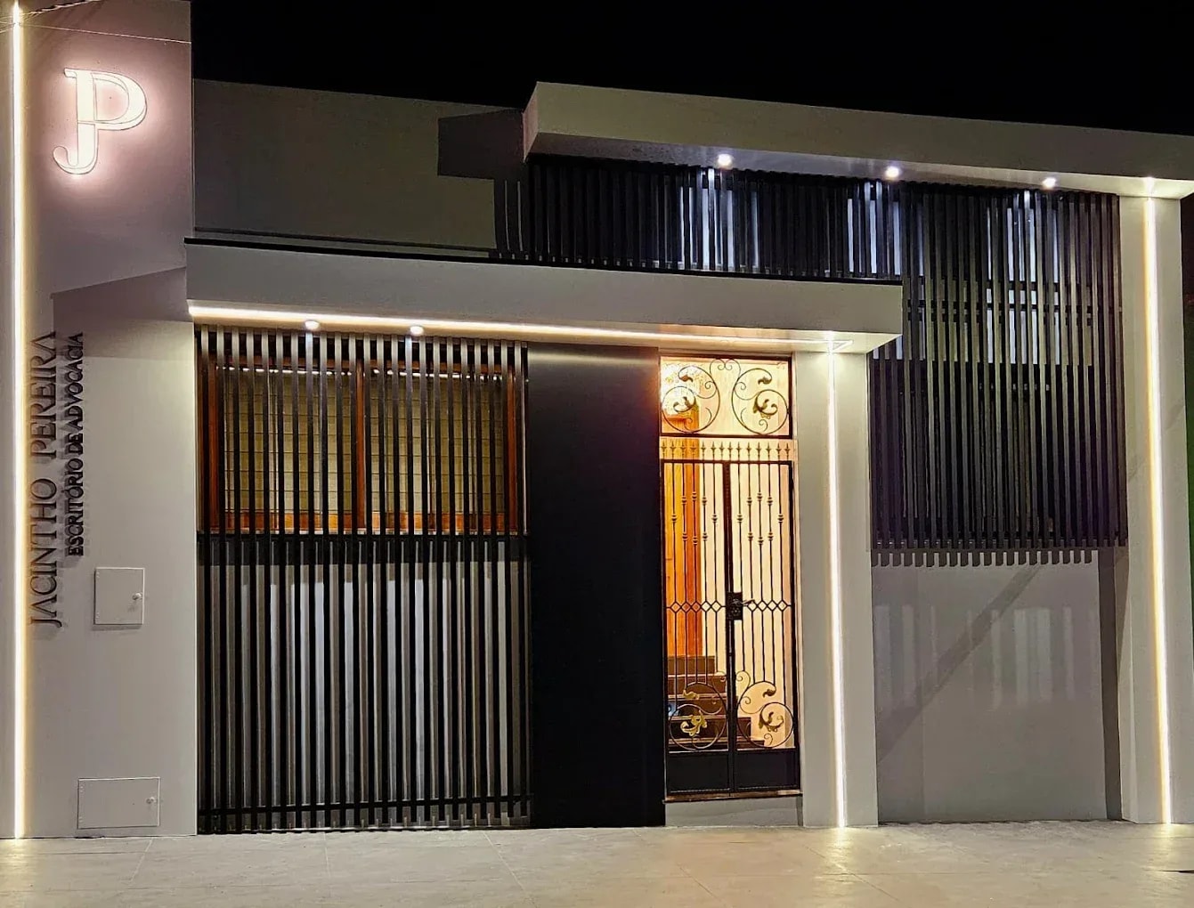 Fachada do escritório Jacintho Pereira iluminada à noite
